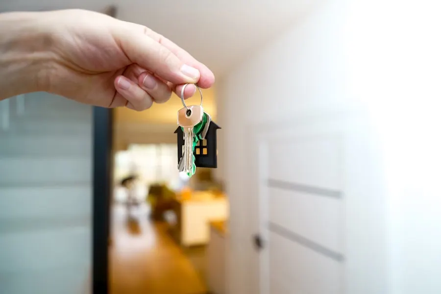 A hand passing over the keys to a home
